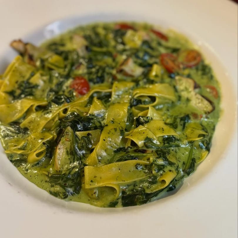 Nonna's Italian Ristorante's pappardelle pasta with creamy green sauce, spinach, and cherry tomatoes.